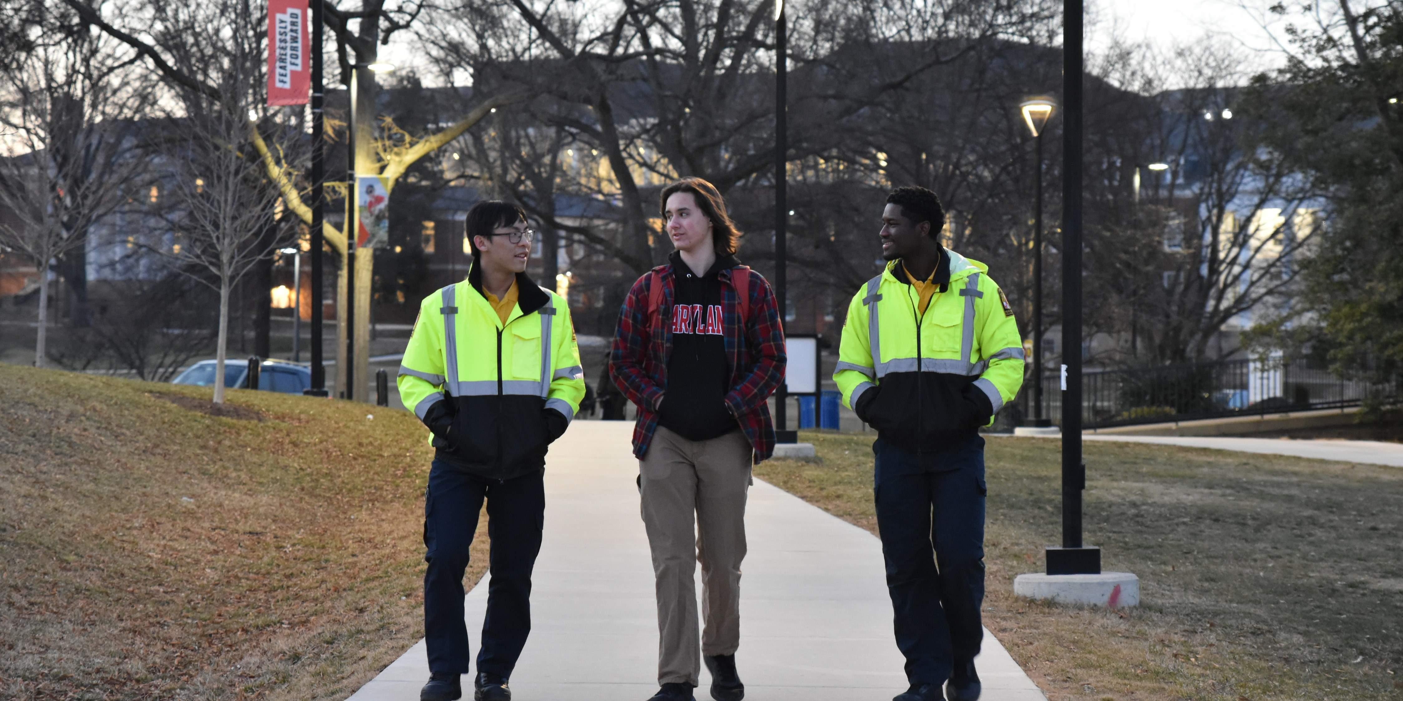 Two Student Police Aides escorting a student on campus