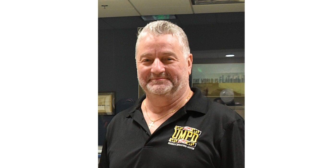Portrait of a man that is wearing a black shirt with UMPD Security Operations Center on the front of the shirt.